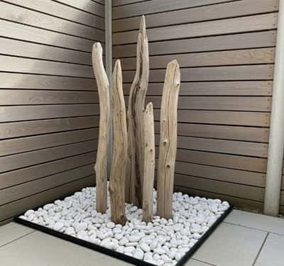 8. Minimalist White Rock & Driftwood Feature