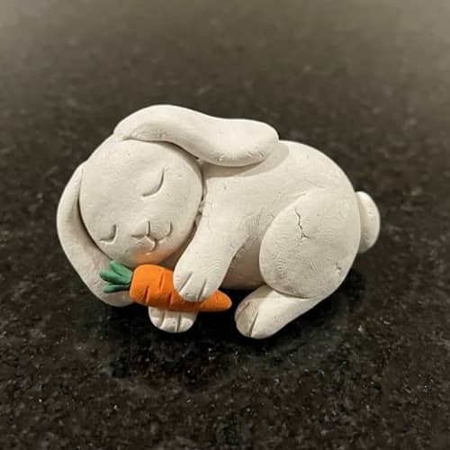 1. Sleepy Bunny Holding a Tiny Carrot